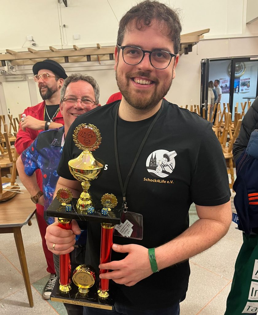 Stolzer Gewinner von Schock4Life e.V. präsentiert den Pokal der Rhein-Sieg Schockmeisterschaft.